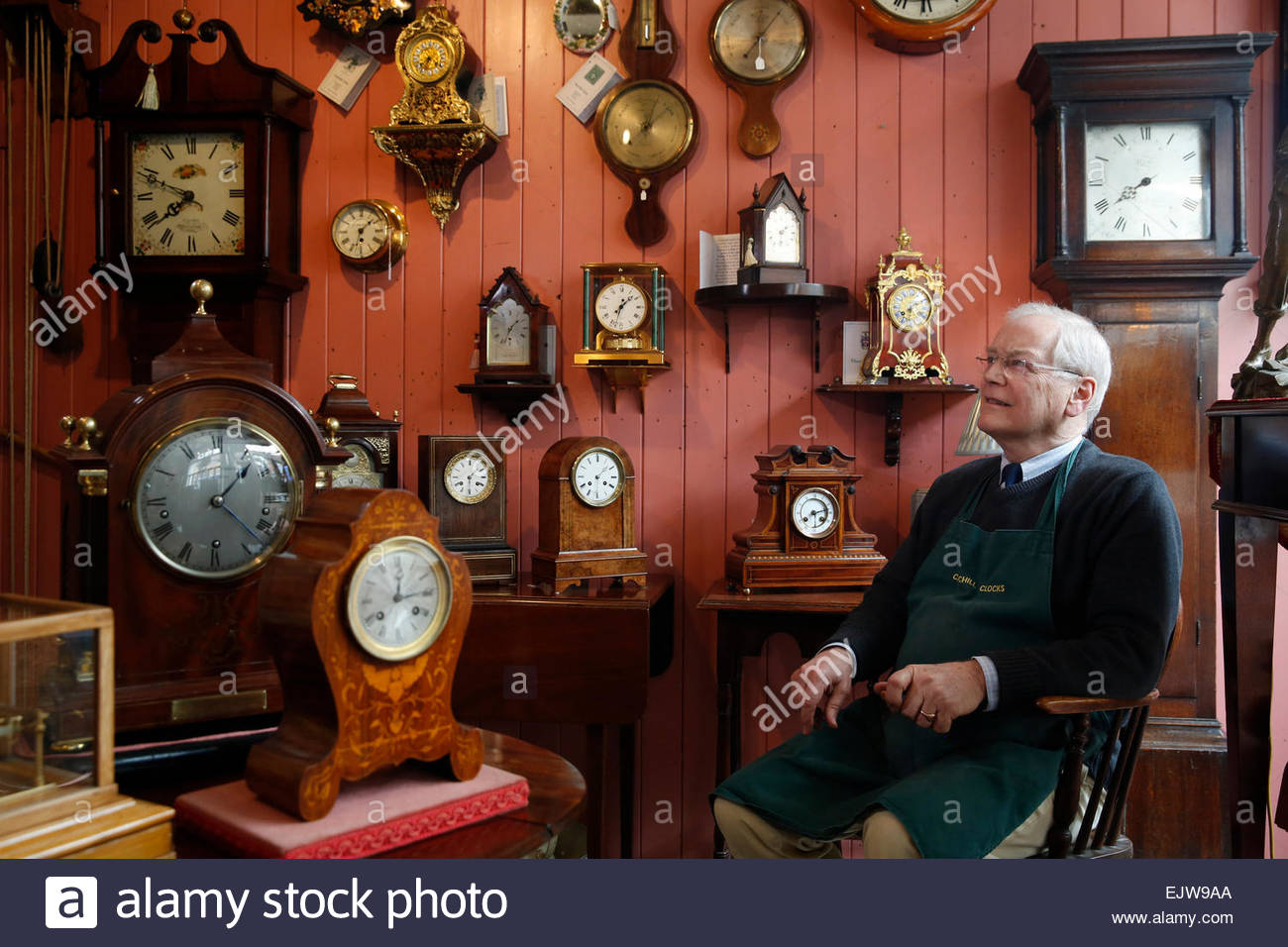 Antique clock restorer William Tyrrell sits among his clocks at Stock