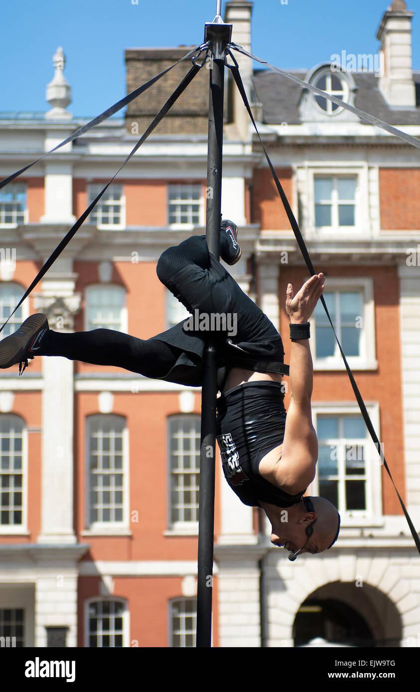 This is Reuben Dotdotdot performing in Covent Garden up 15 ft high pole supported only by four volunteers from the crowd. Stock Photo