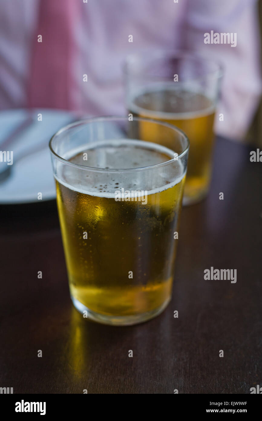 Two glass of beer over business man background Stock Photo