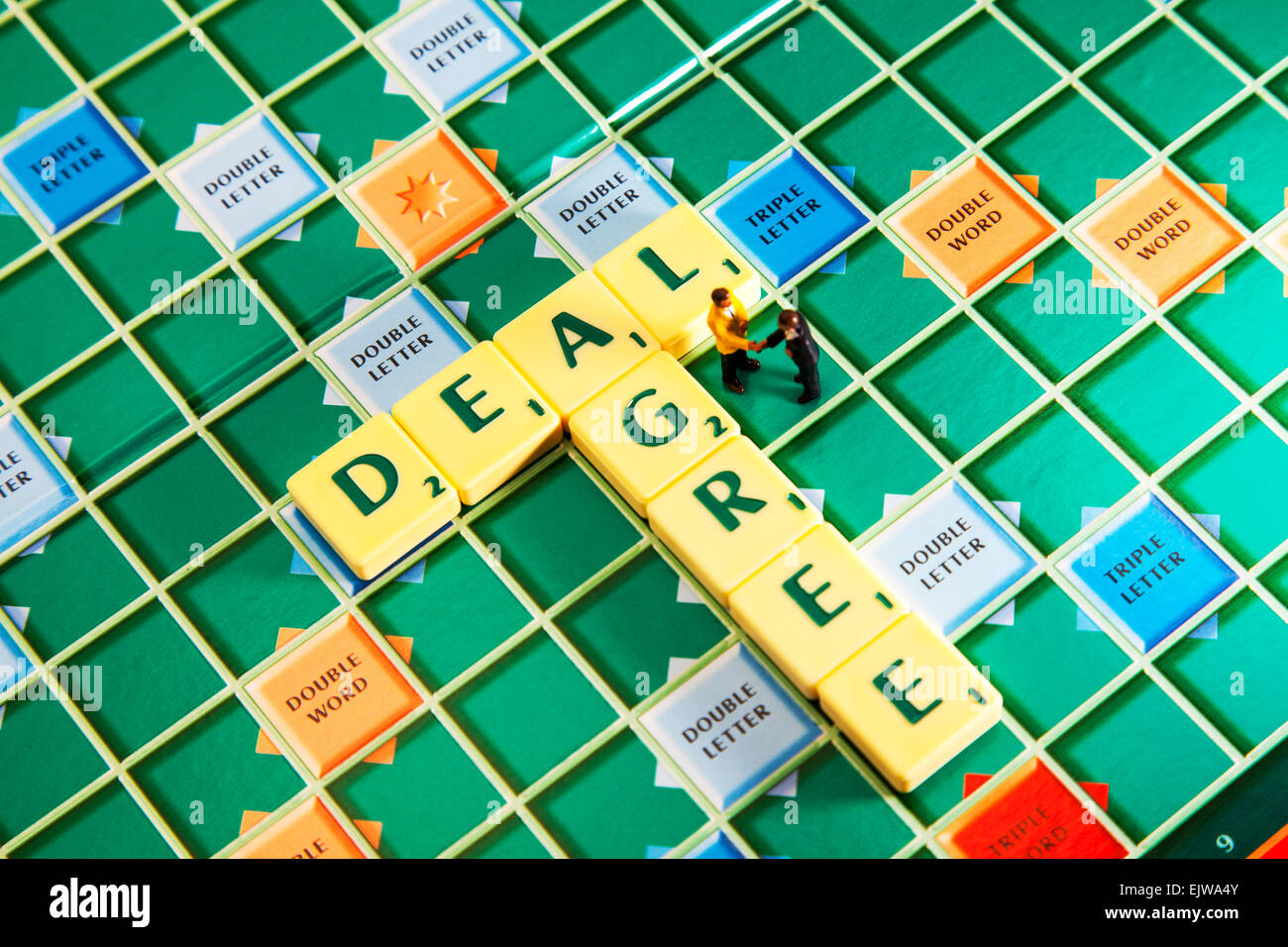 agree deal hand shake hands seal binding gentlemen agreement words using scrabble tiles to illustrate spelling spell out Stock Photo