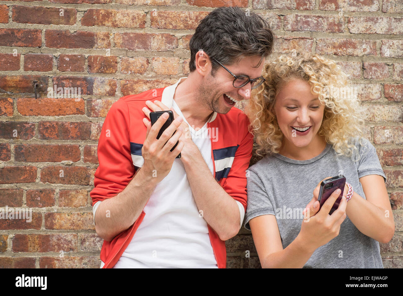 Couple sharing messages on cell phones Stock Photo