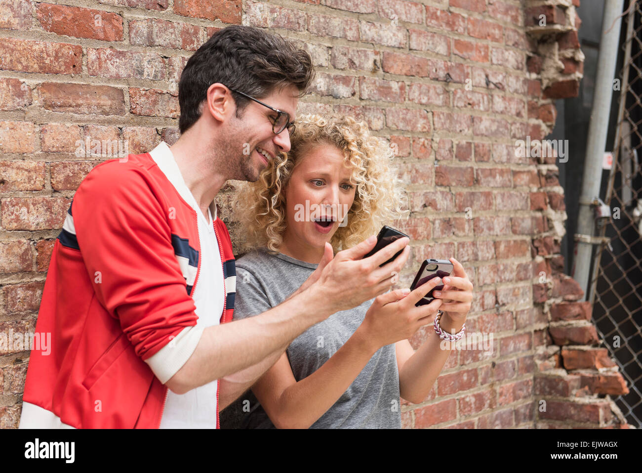 Couple sharing messages on cell phones Stock Photo