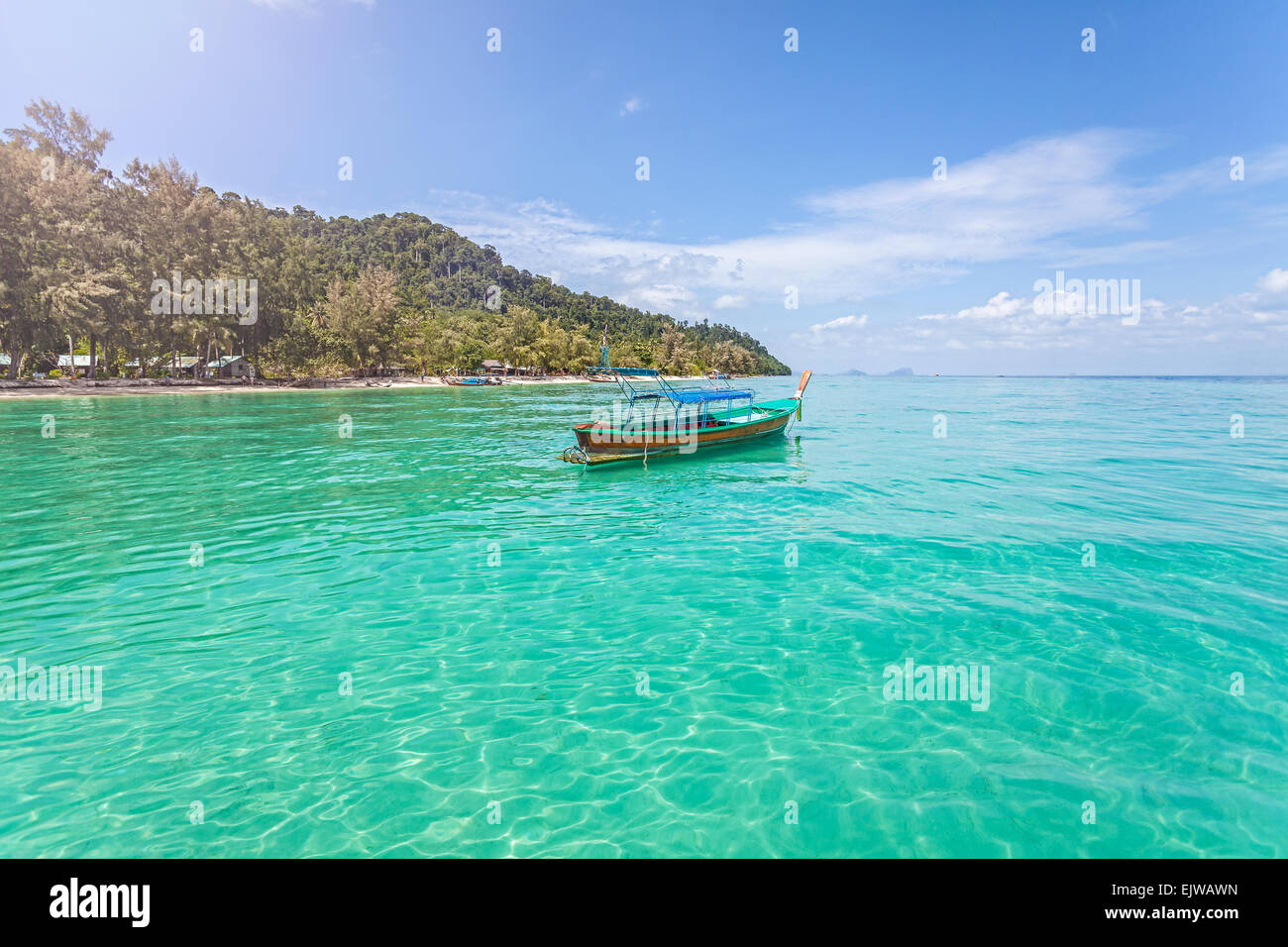 Little boat by tropical island, perfect vacation concept. Stock Photo