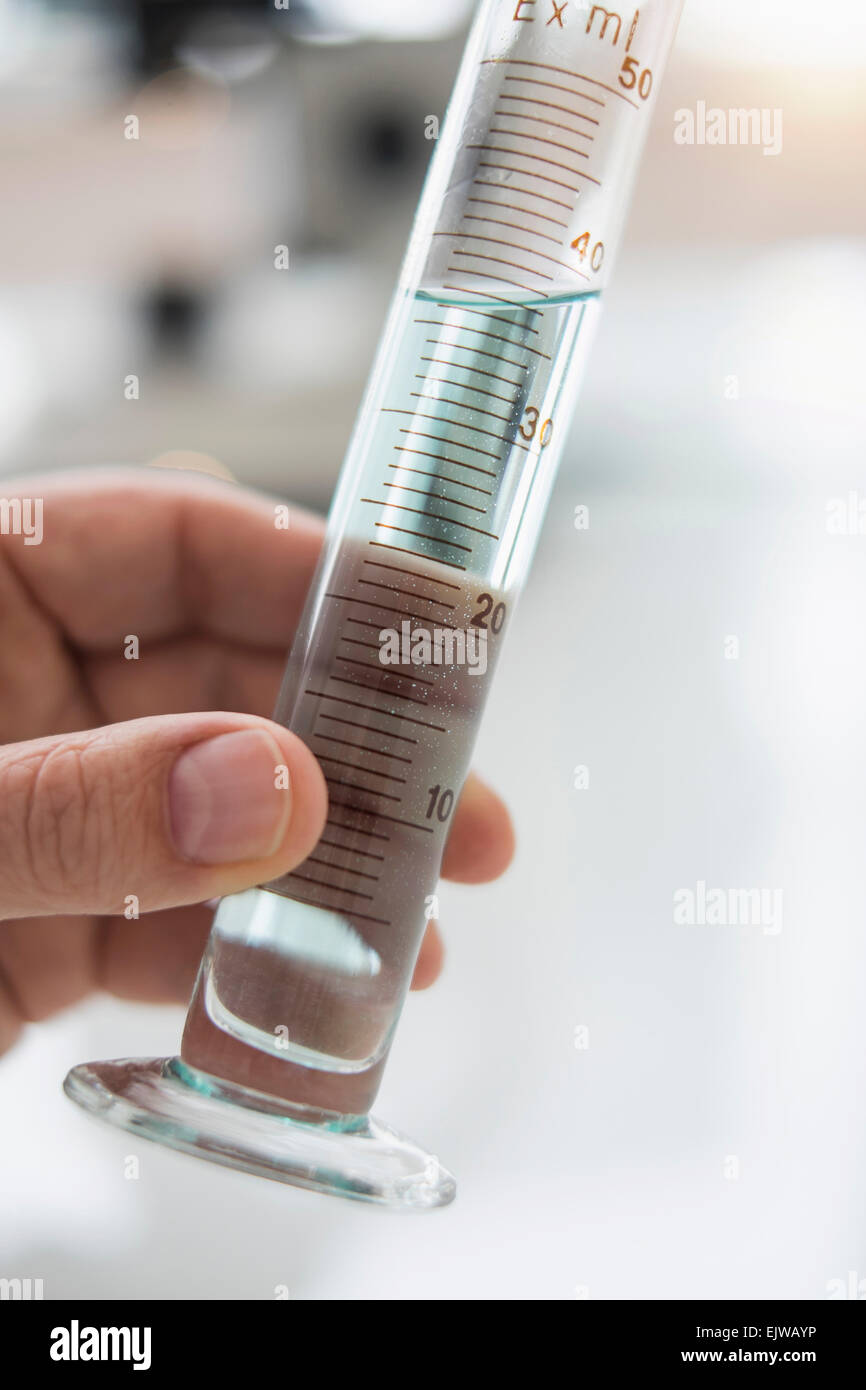 Close up of man's hand holding test tube with liquid Stock Photo