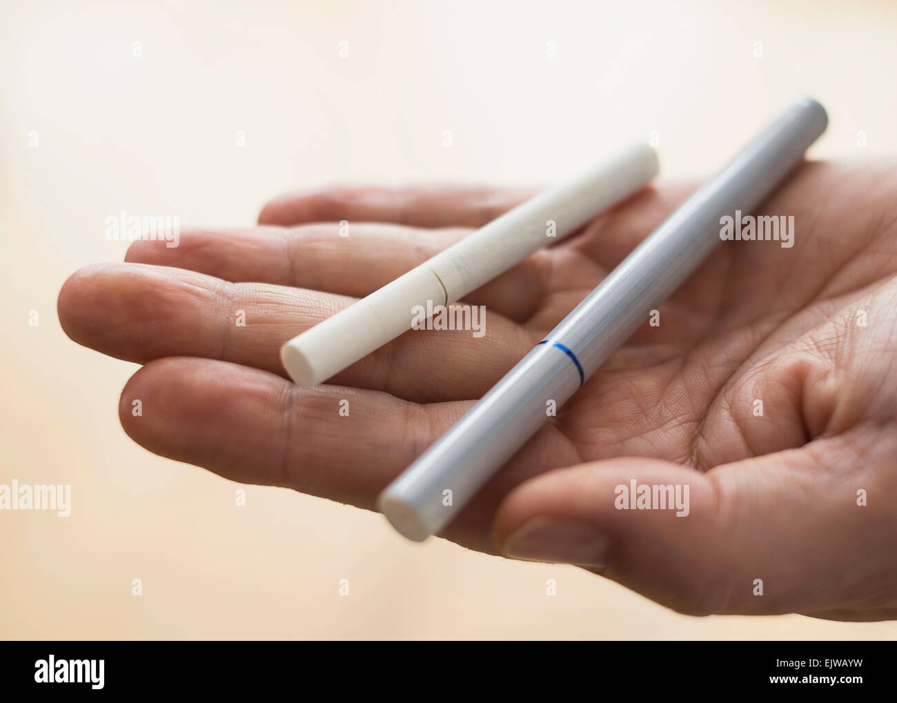 Close up of man's hand holding cigarette and e-cigarette Stock Photo