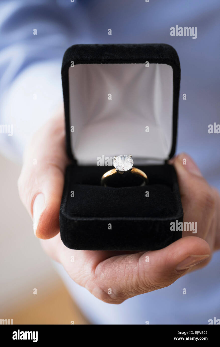 Close up of man's hand holding open box with engagement ring Stock Photo