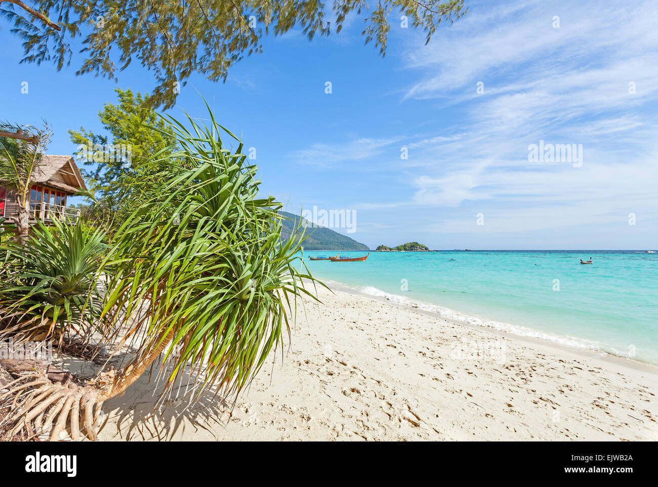 Bungalow by a pristine beach, summer paradise background. Stock Photo