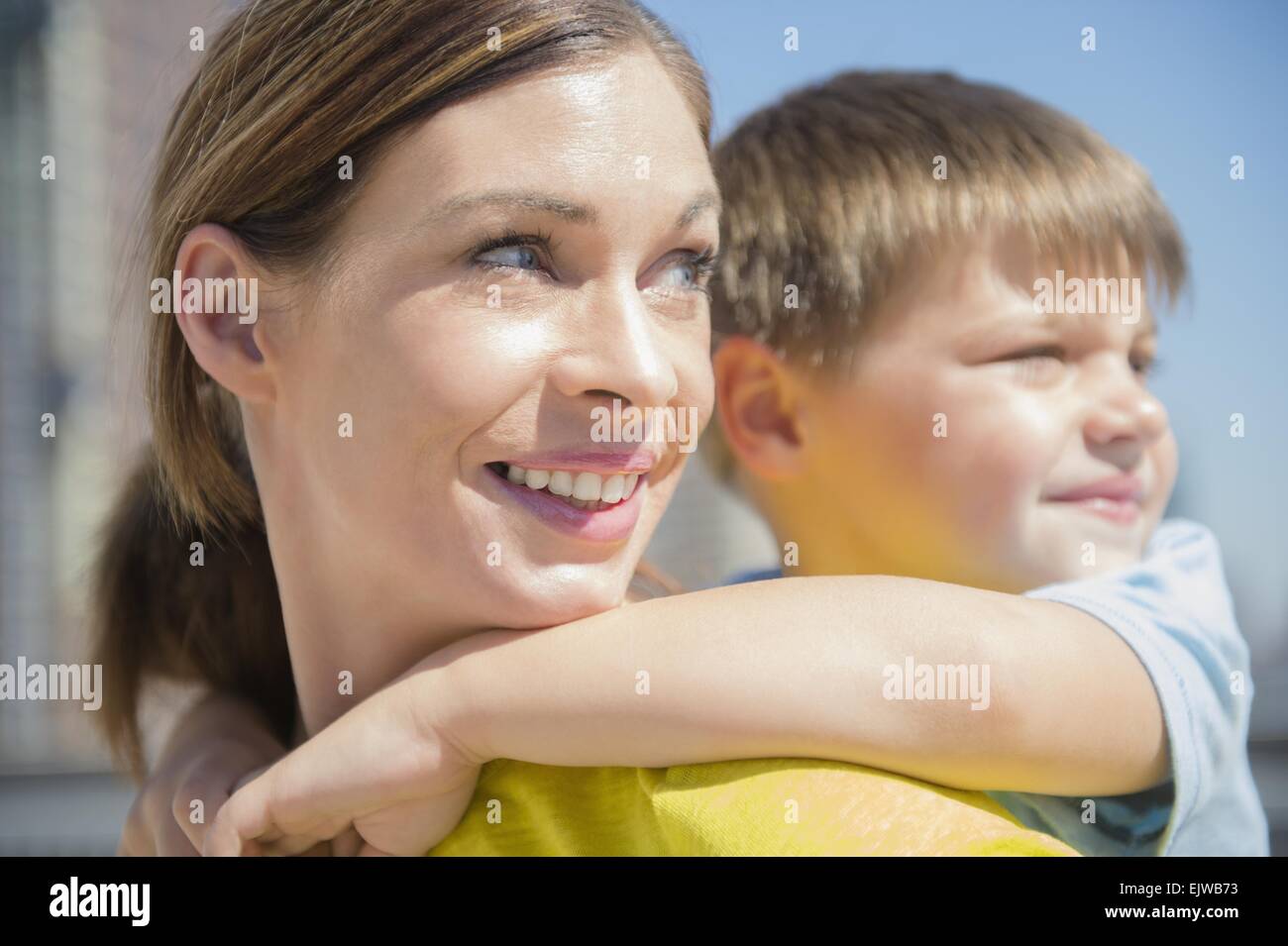 Mother giving her son (6-7) piggyback ride Stock Photo