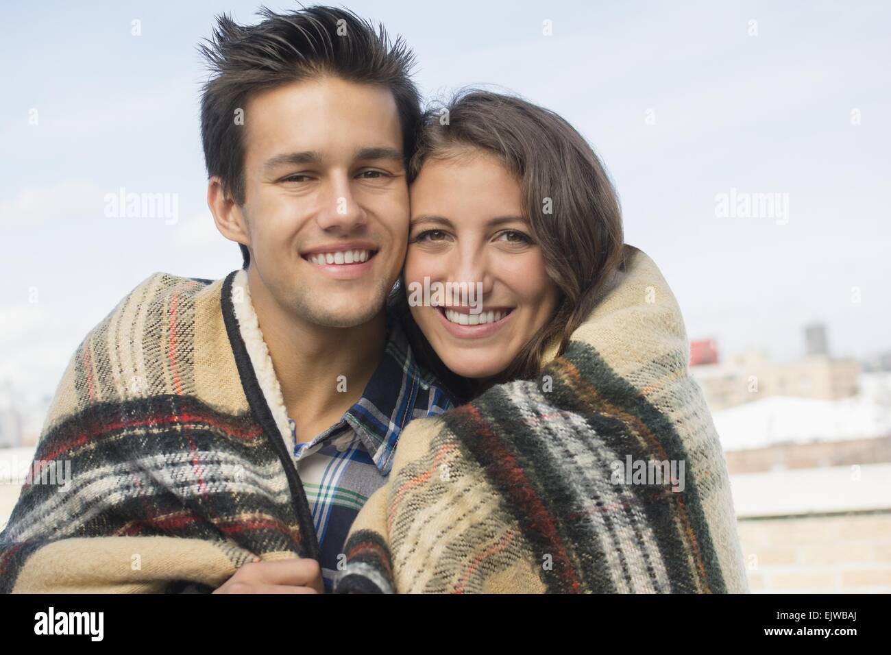USA, New York State, New York City, Brooklyn, Portrait of young couple wrapped in blanket Stock Photo