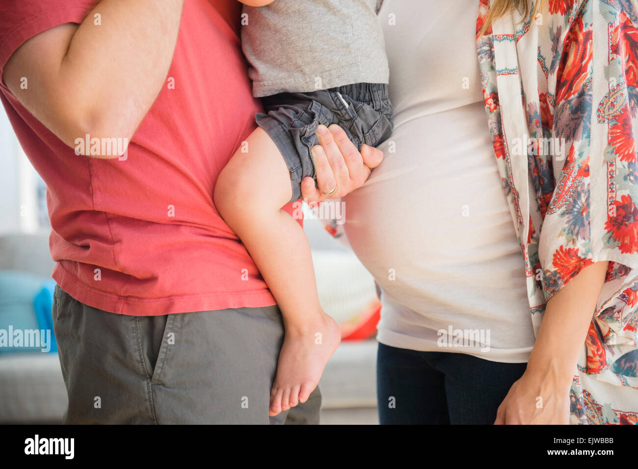 Mid-section of parents with son (2-3) in living room Stock Photo