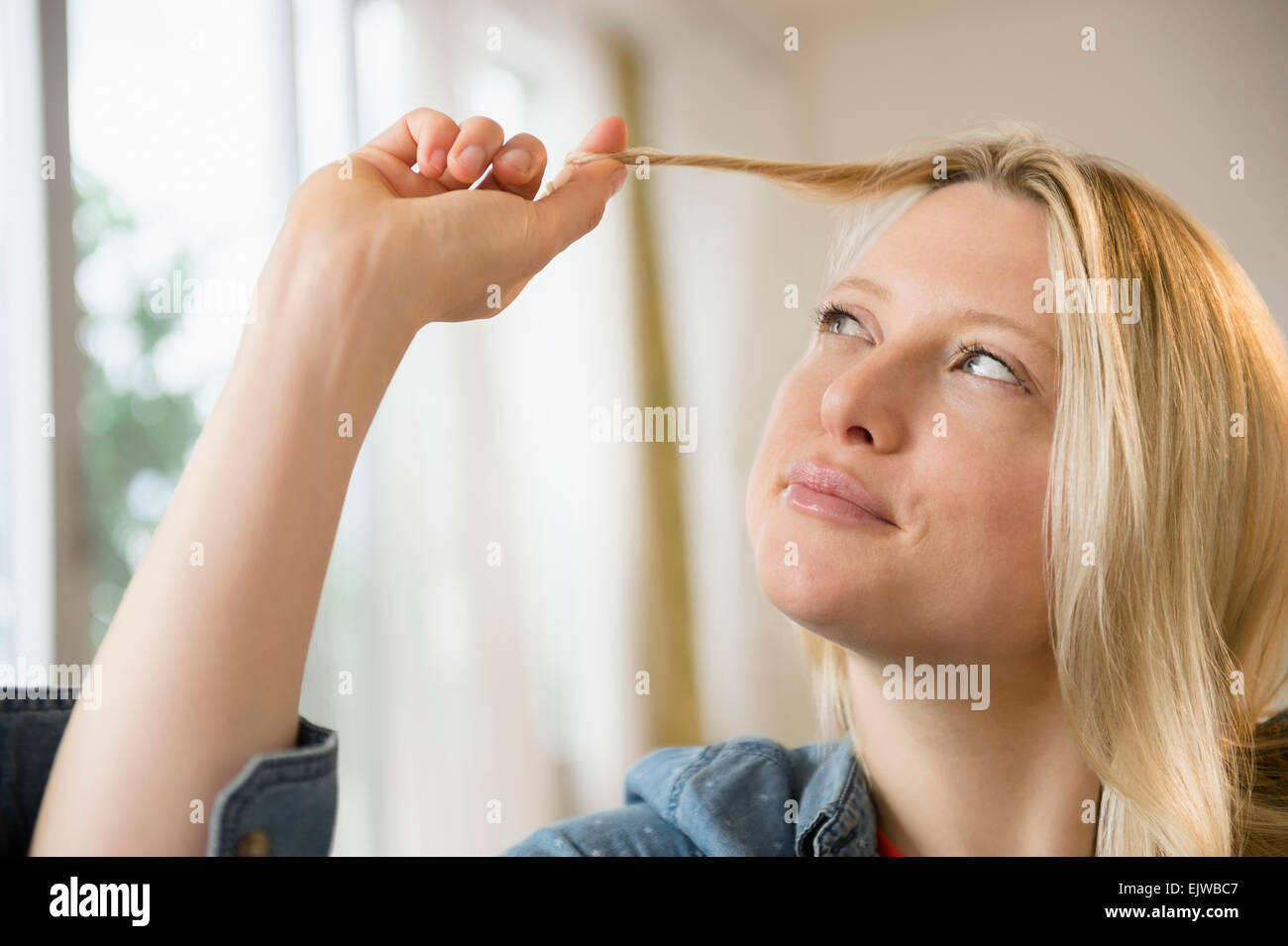 Woman twisting her hair Stock Photo