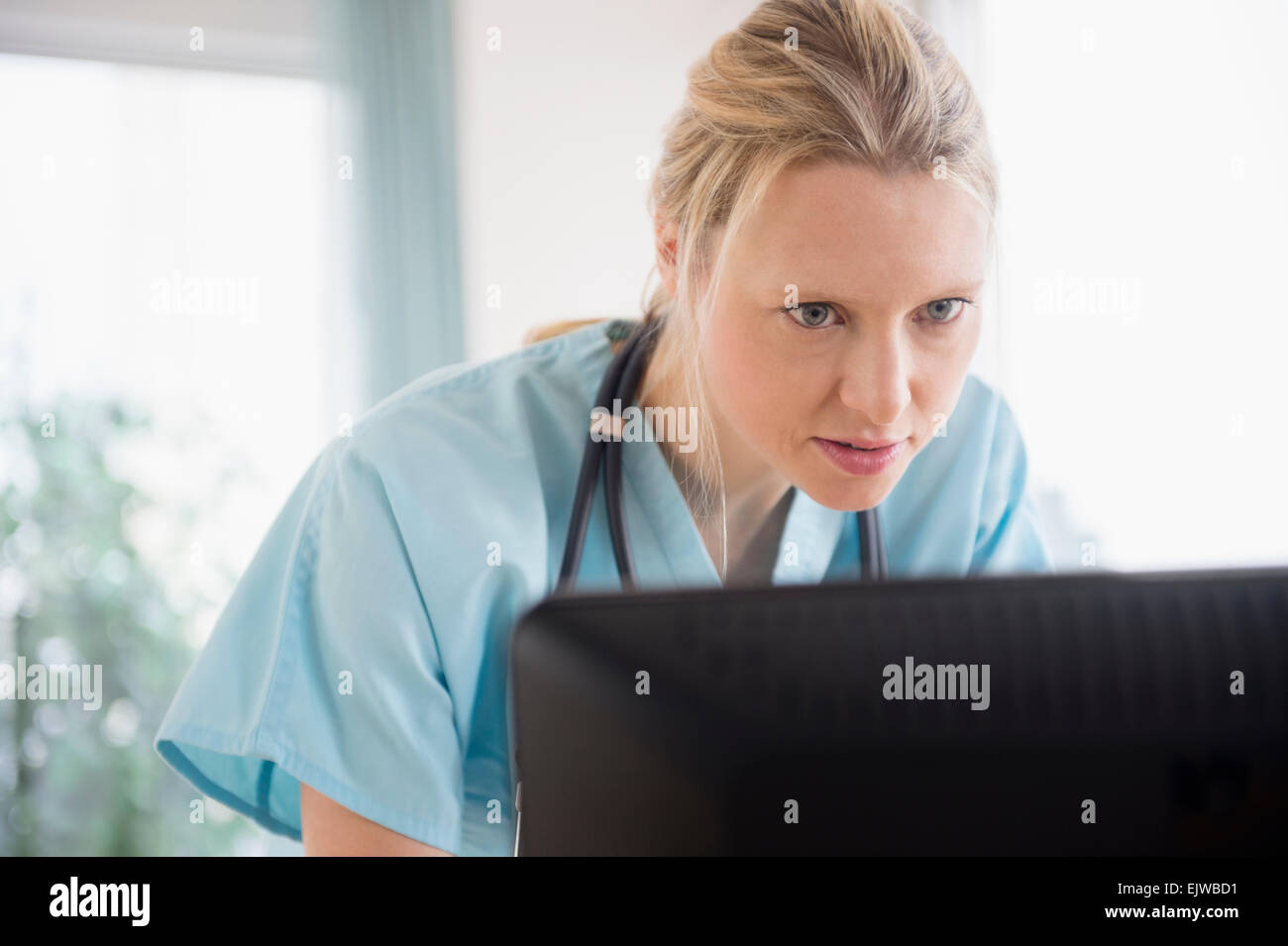 Doctor looking at computer monitor Stock Photo