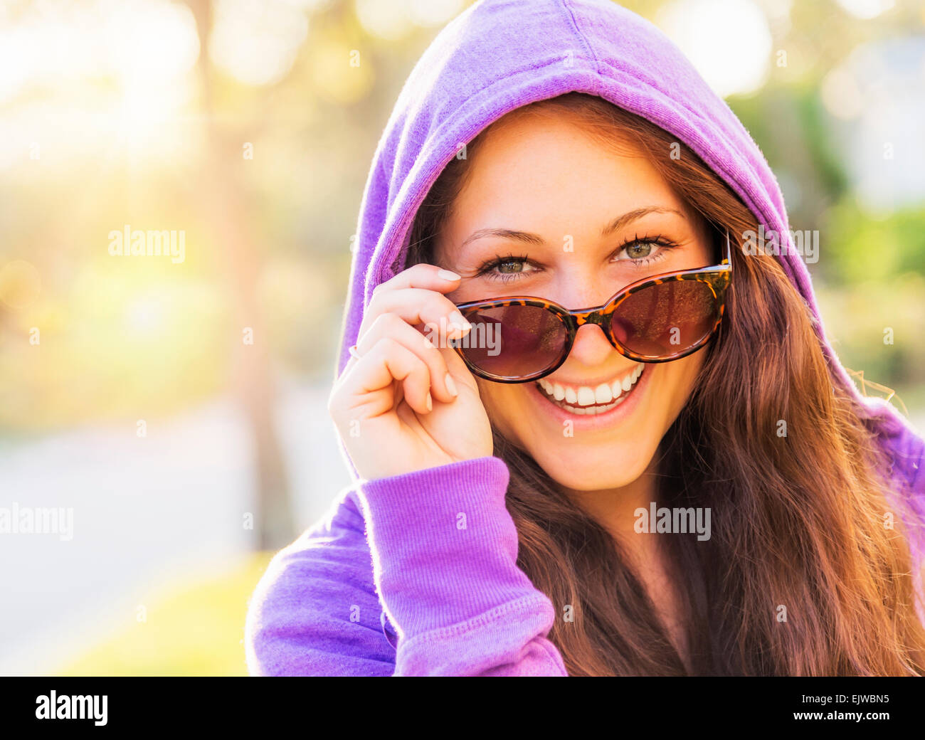 USA, Florida, Jupiter, Portrait of smiling woman in hoodie with sunglasses Stock Photo