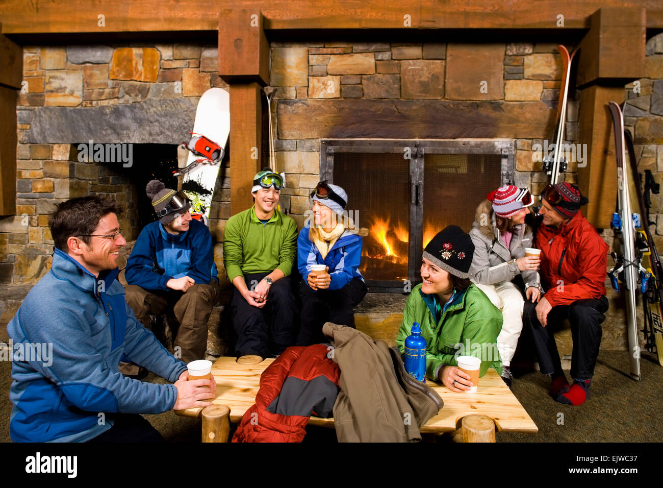 USA, Montana, Whitefish, Group of skiers hanging out at fireplace Stock Photo