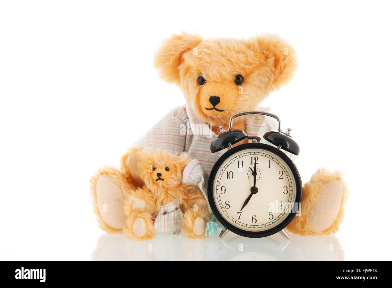 Stuffed handmade bears in pajamas with alarm clock  isolated over white background Stock Photo