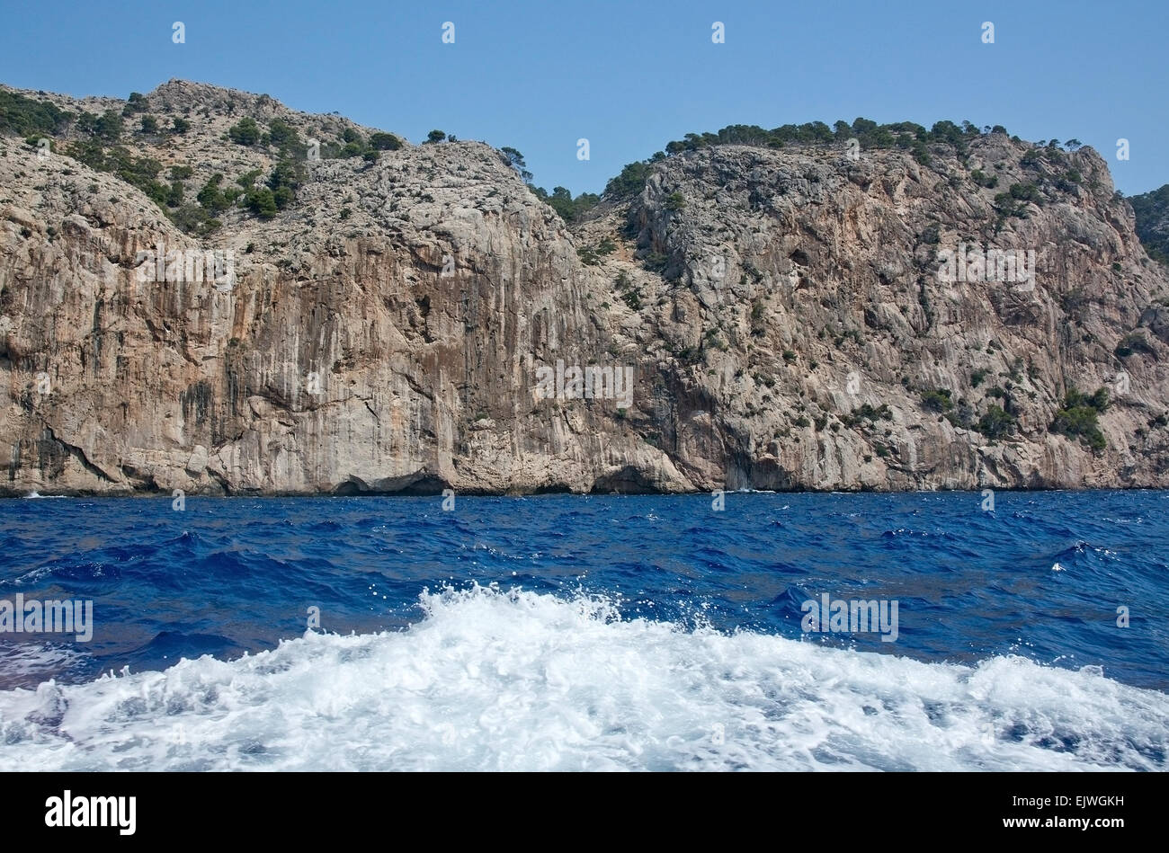 Cliffs ocean and boat foam in Mallorca, Balearic islands, Spain. Stock Photo