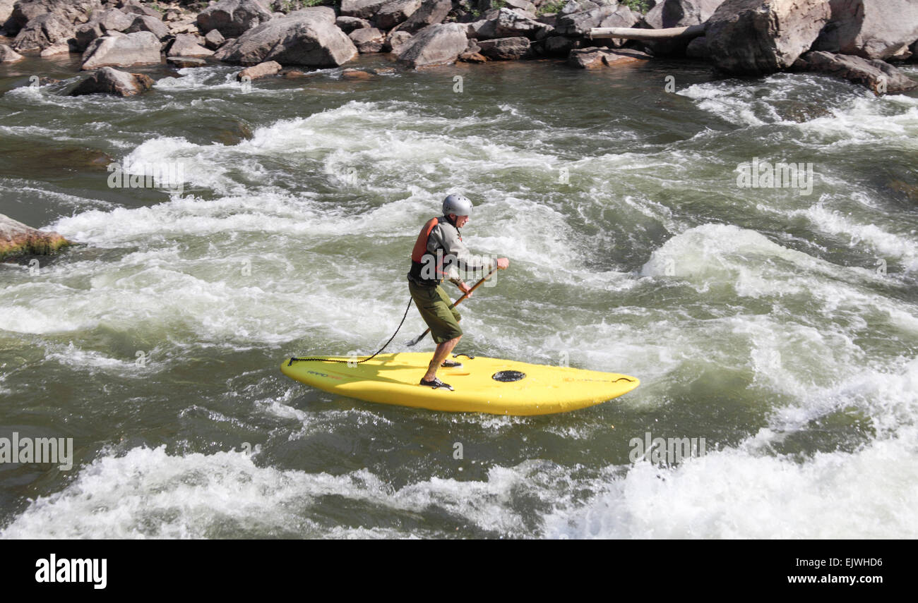 Man stands on board going through rapids in Glenwood Canyon Stock Photo