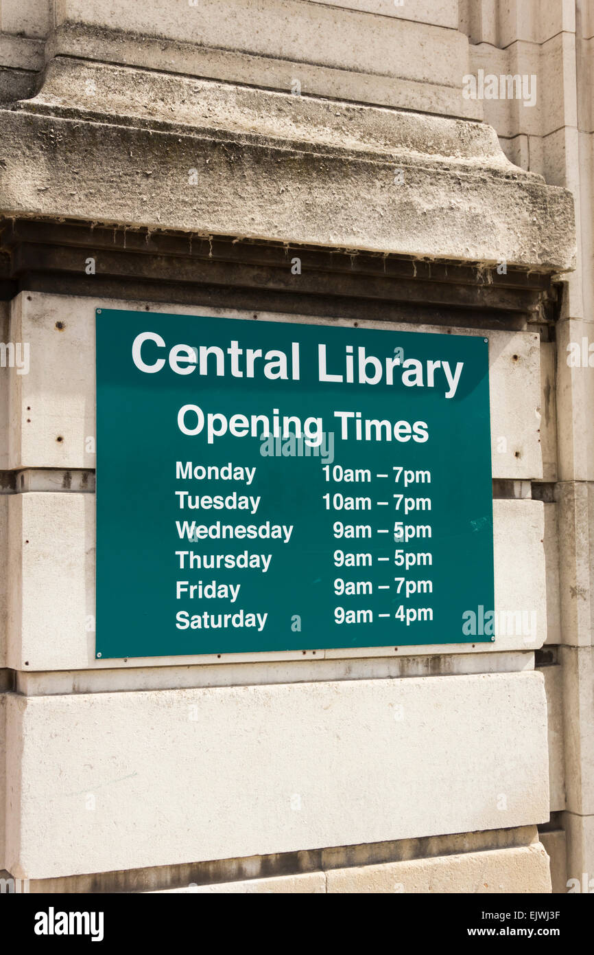 Information board outside the entrance to Stockport Central Library showing the daily opening times. Stock Photo