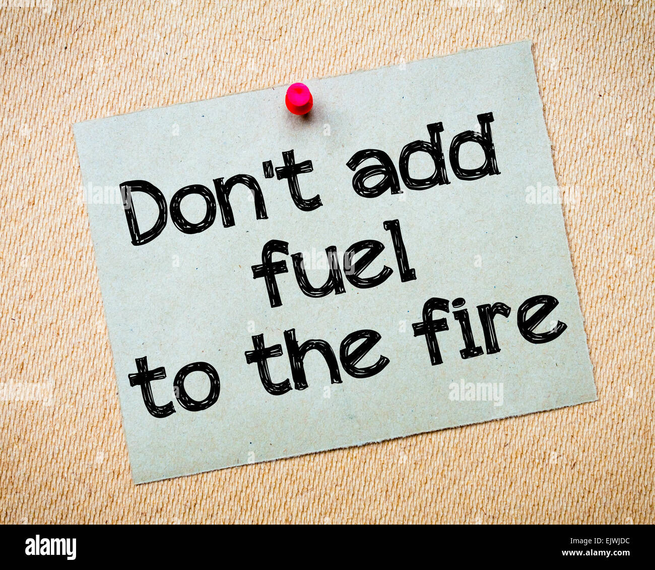 Don't add fuel to the fire Message. Recycled paper note pinned on cork
