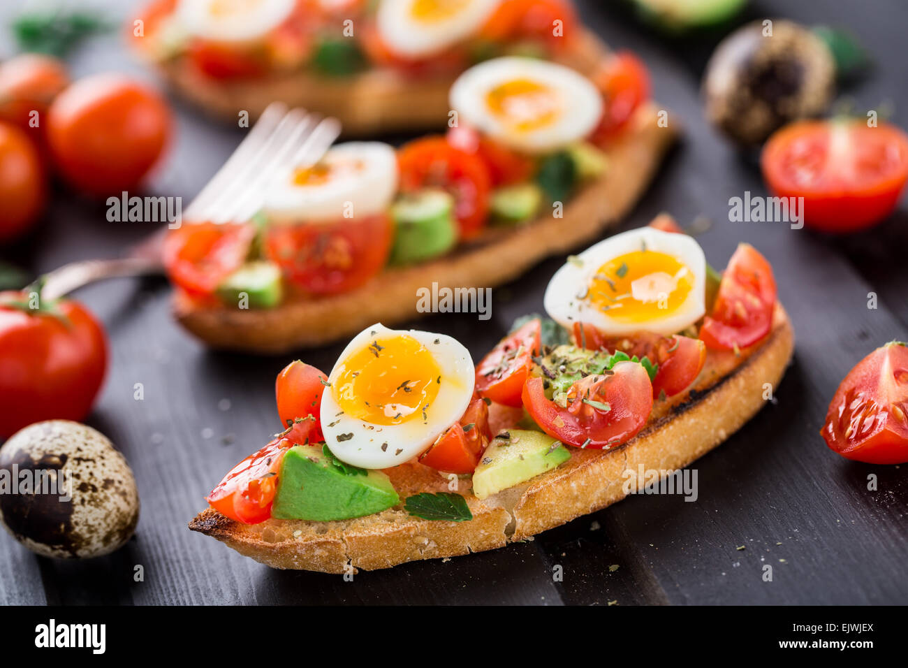 Bruschetta with tomato, avocado and quail egg Stock Photo Alamy