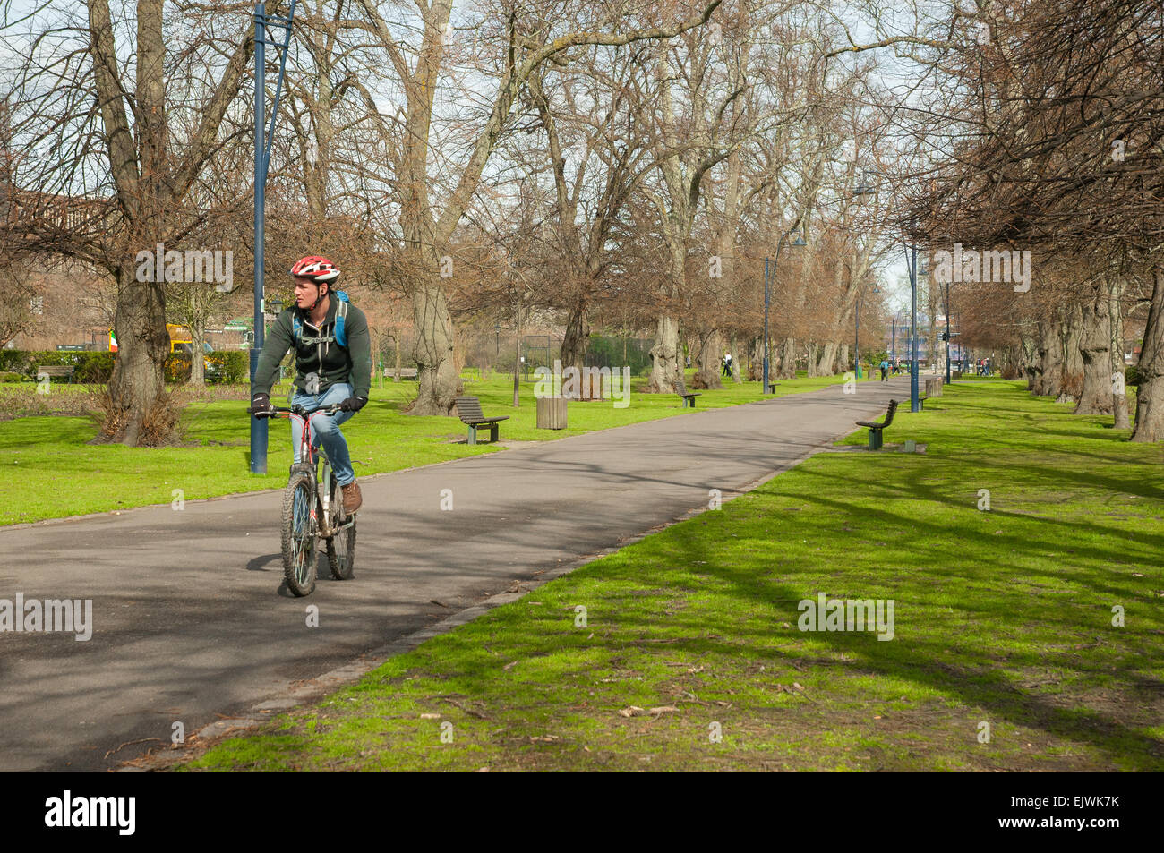 A cyclist riding through a Palmerston park in Southampton England. Un ciclista paseando por Palmerston park de Southampton Stock Photo