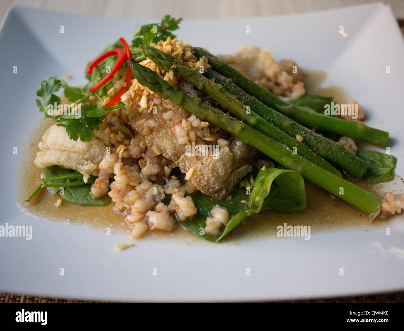 fried haddock fish spinach asparagus garlic sauce Stock Photo Alamy