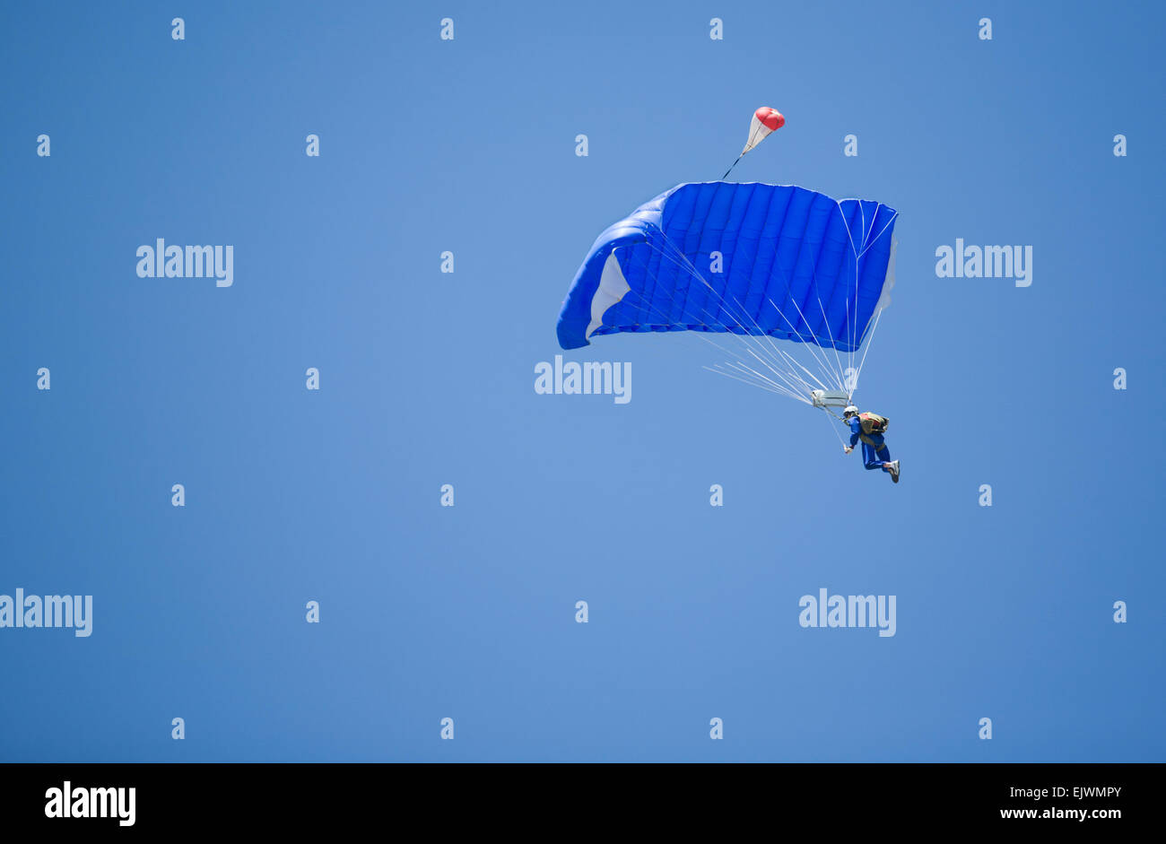 A skydiver performing skydiving with blue sky in the background Stock Photo