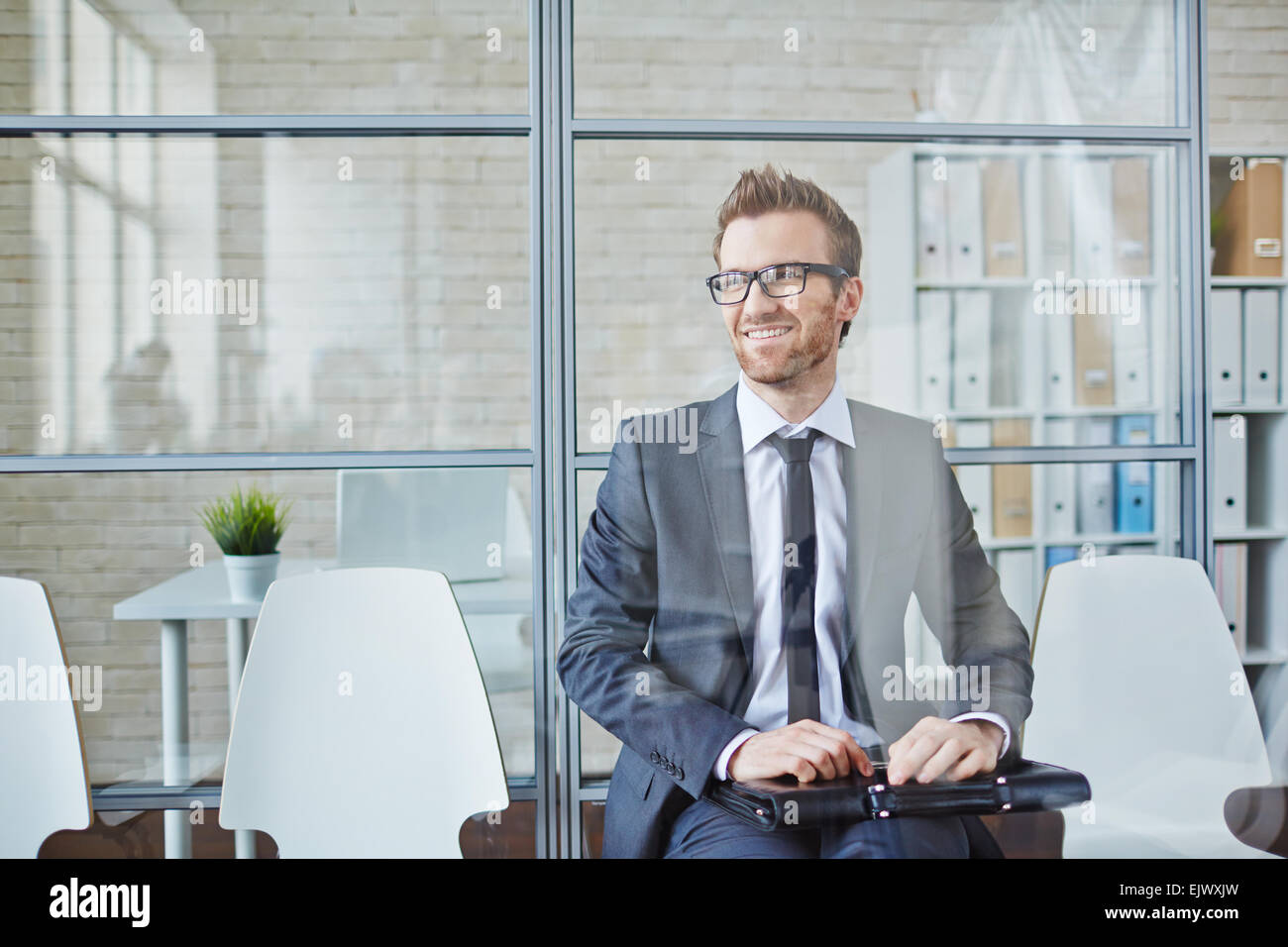 Successful young businessman sitting in office Stock Photo - Alamy