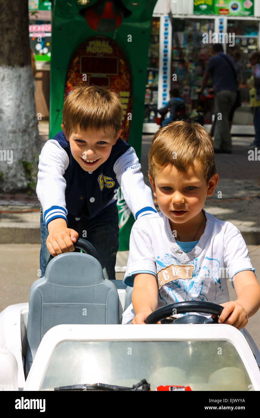 NIKOLAEV, UKRAINE - June 21, 2014: Kids in the play area riding a toy car Stock Photo