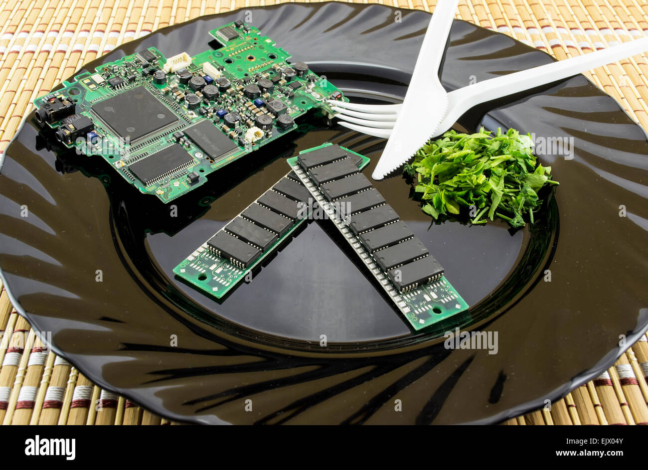 Consumer electronics concept with electronic components on a plate served alongside parsley Stock Photo