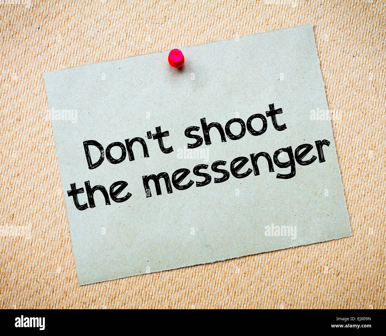 Don't shoot the messenger Message. Recycled paper note pinned on cork