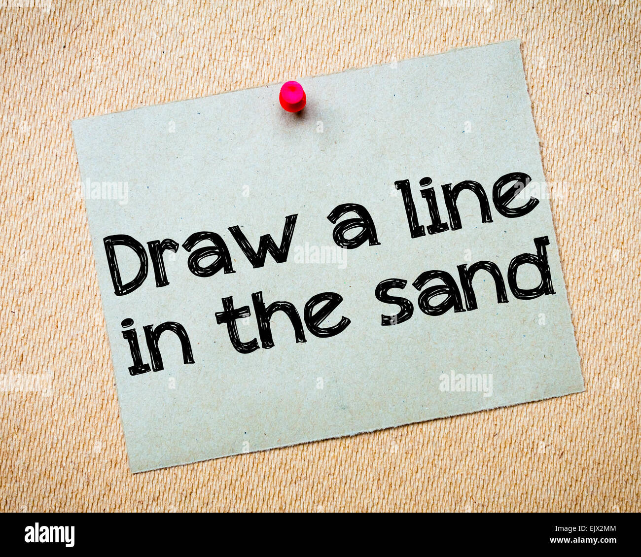 Draw a line in the sand Message. Recycled paper note pinned on cork board. Concept Image Stock Photo