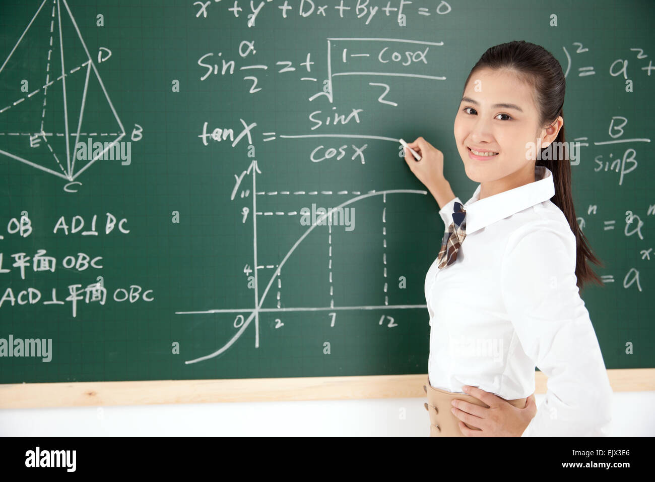 High school girls write mathematical formula in front of the blackboard Stock Photo
