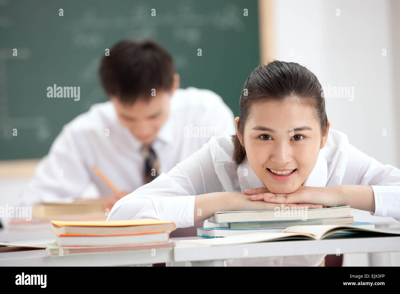 The classroom of high school girls leaned across the table Stock Photo