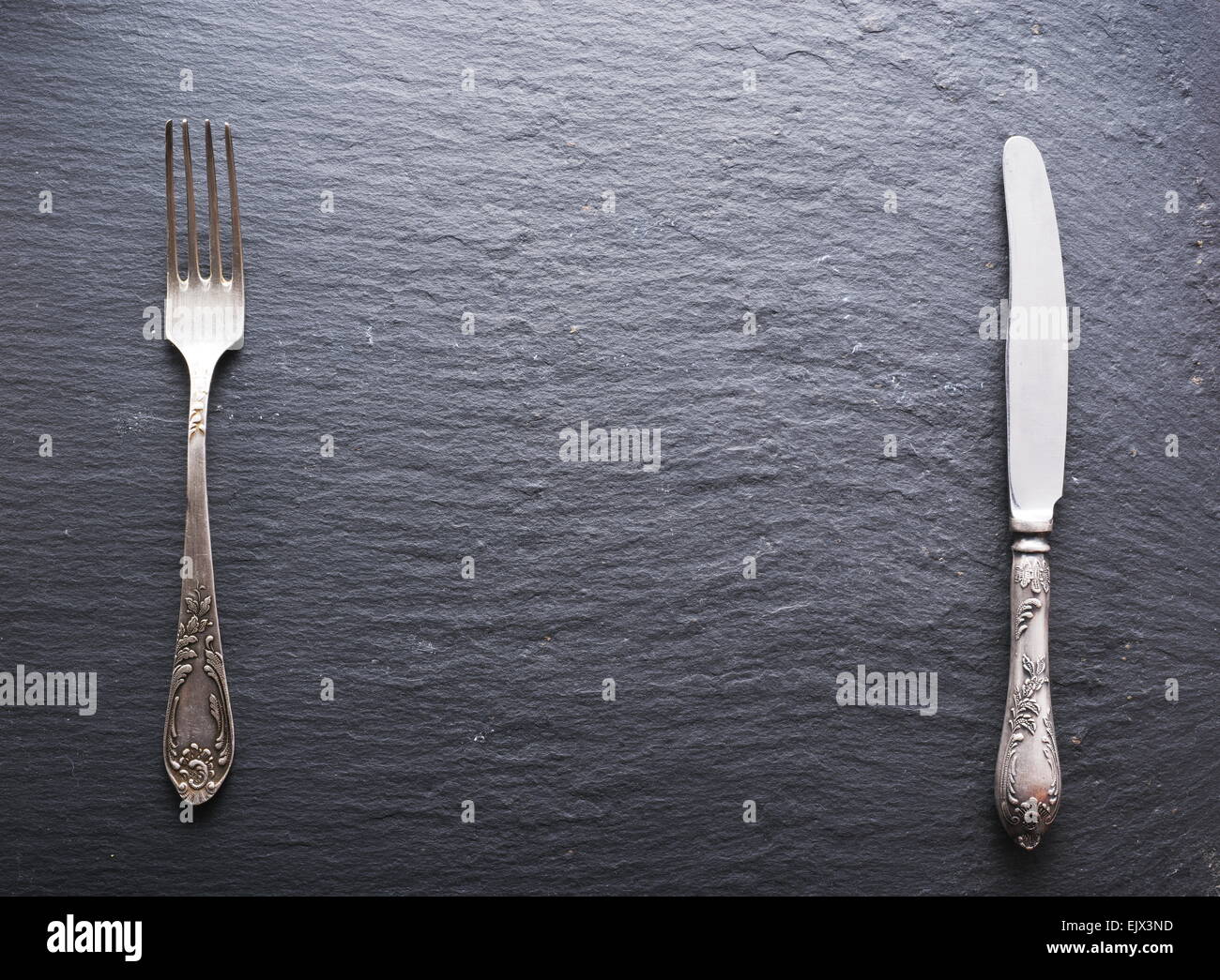 Silver cutlery on a dark gray background. Stock Photo