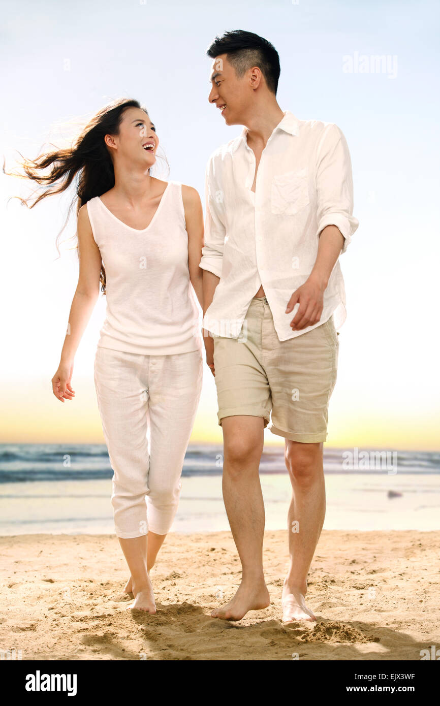 The romantic young lovers walk on the beach Stock Photo