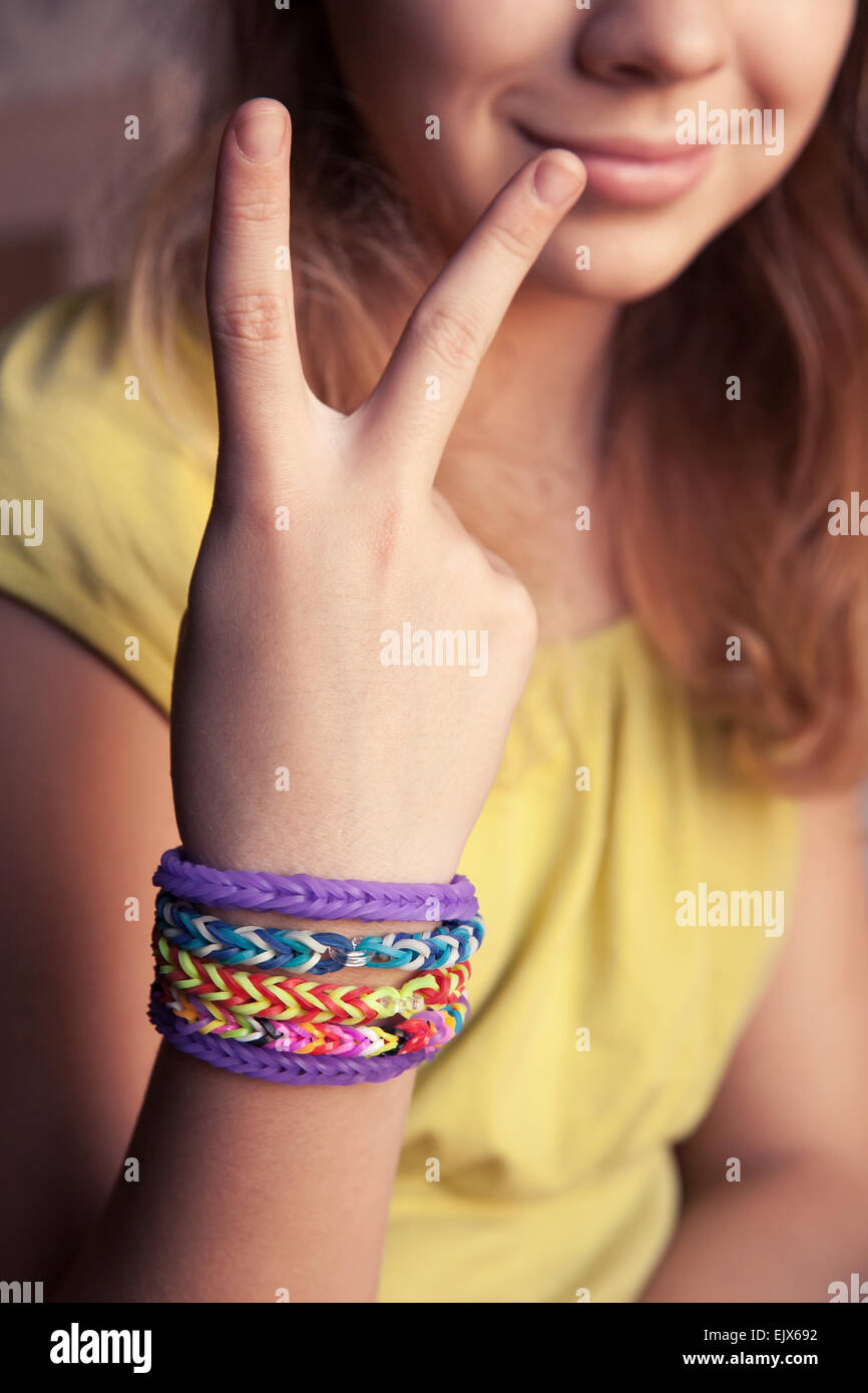 Caucasian girl showing two fingers with colorful rubber rainbow loom  bracelets on her wrist, trendy teenagers fashion Stock Photo - Alamy