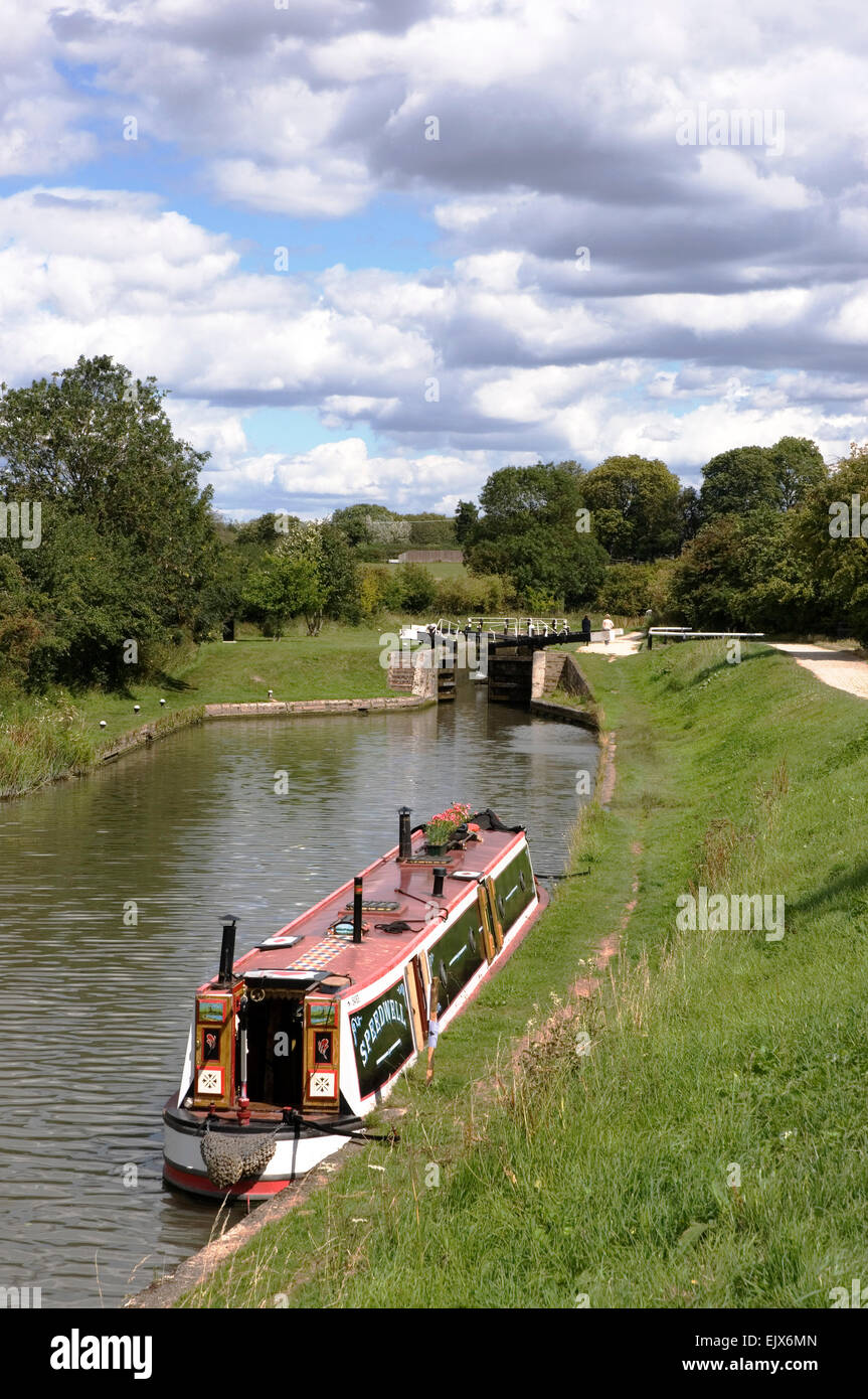 Bucks - Marsworth - on the Grand union Canal -colourful narrow boat moored below lock - bright summer day - clouds + blue sky Stock Photo