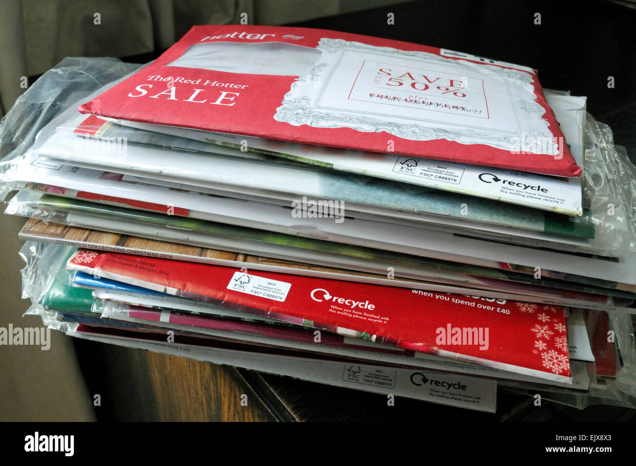 Pile of unopened envelopes containing clothing catalogues and showing recycle logo London, UK Stock Photo