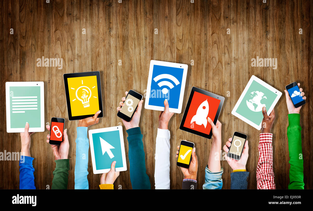 Group of Hands Holding Digital Devices with Symbols Stock Photo - Alamy