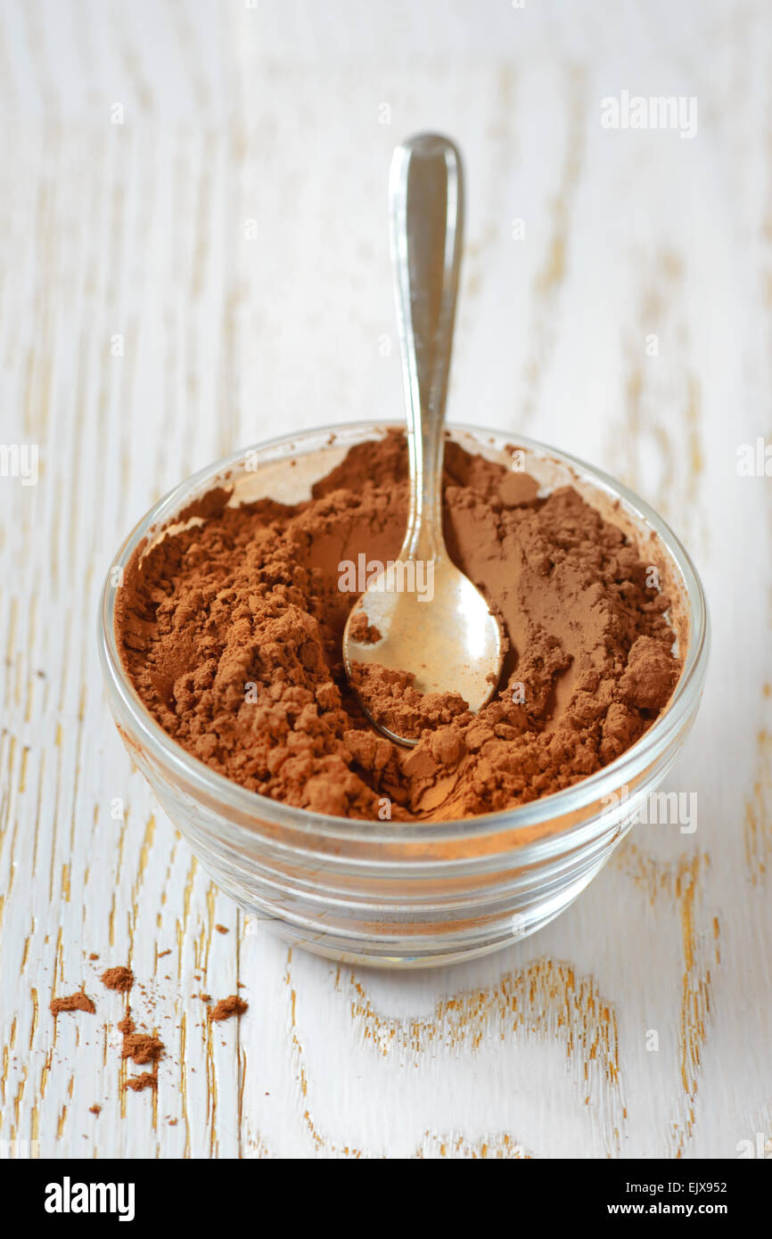 cocoa powder with a spoon on a wooden table Stock Photo