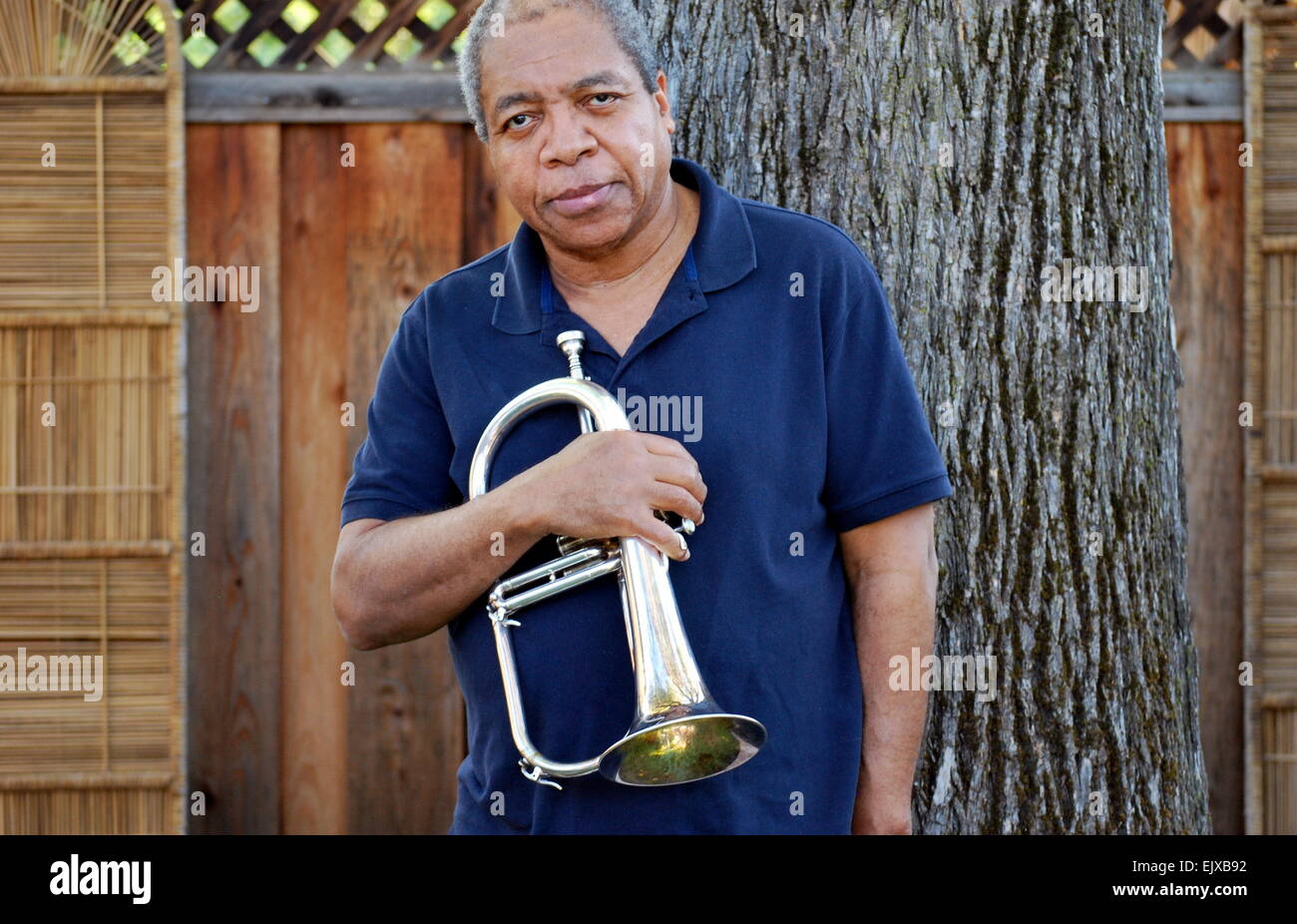 Jazz musician posing with his flugelhorn outside Stock Photo Alamy