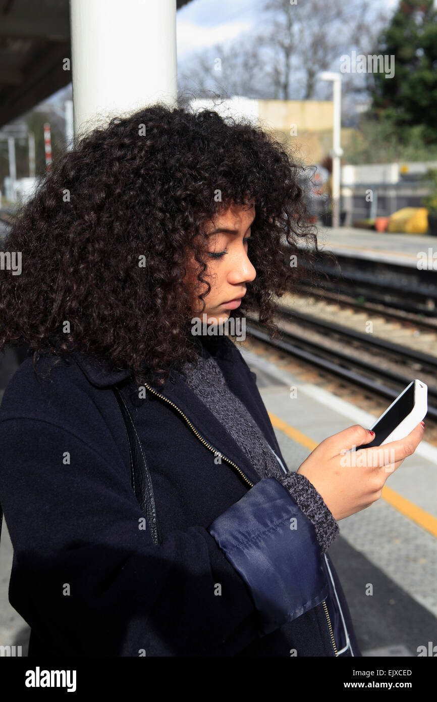 united kingdom london acton central overground station a teenage girl texting Stock Photo