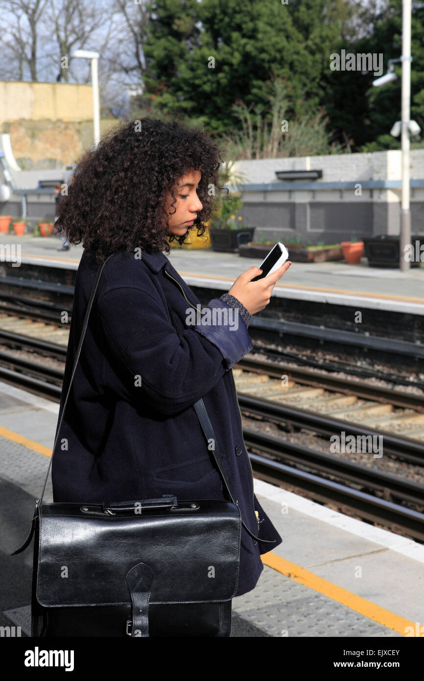 united kingdom london acton central overground station a teenage girl texting Stock Photo