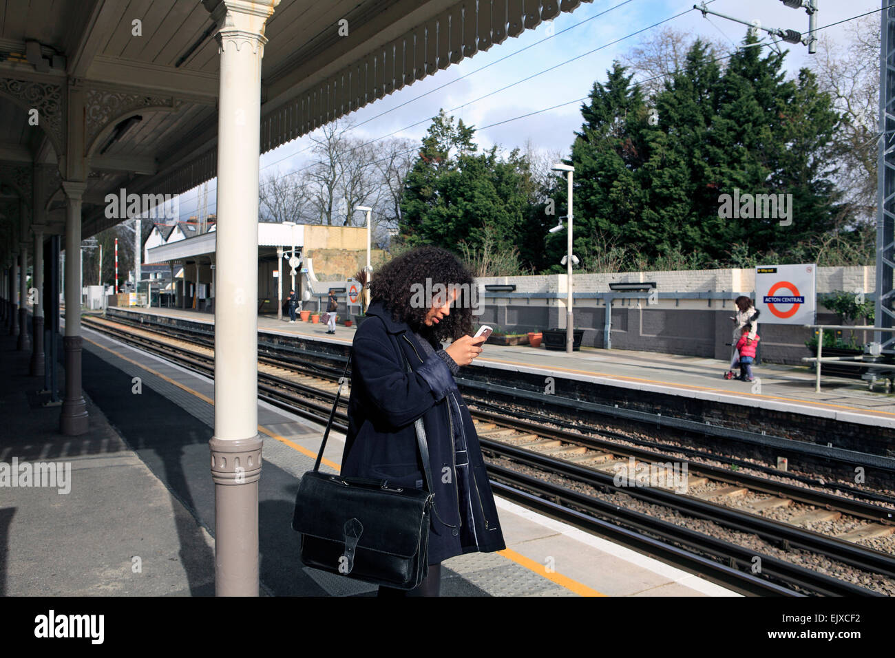 united kingdom london acton central overground station a teenage girl texting Stock Photo