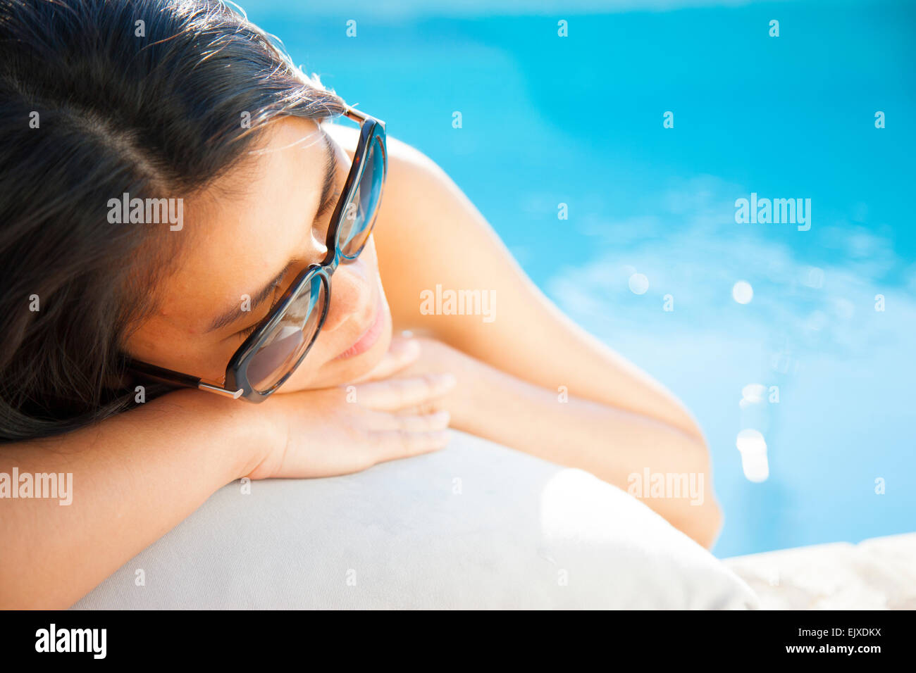 Woman Lying on Swimming Pool Edge Stock Photo