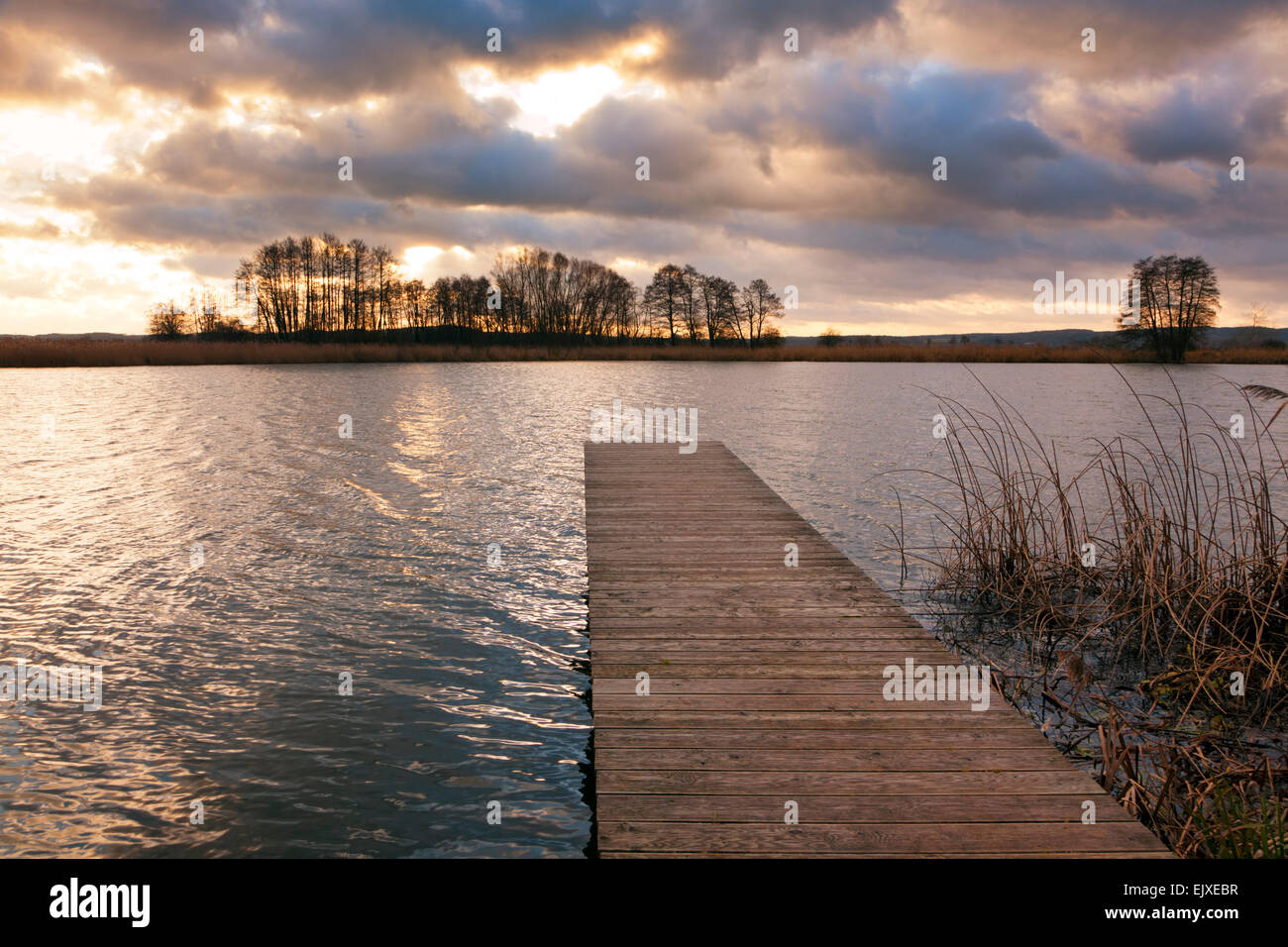 Wooden jetty on the shore of Elbe river near Amt Neuhaus, Lower Saxony, at sunset Stock Photo