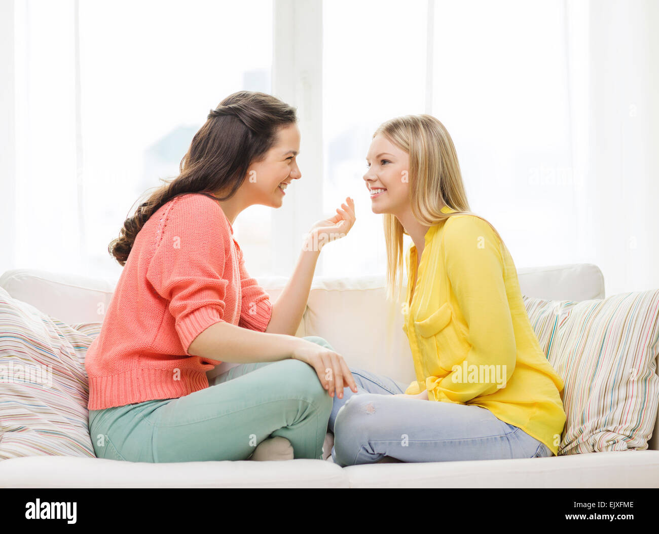 Привела подругу с разговорами. Две девушки беседуют. Разговор двух подруг на диване. Подруги болтают на диване. Подруги общаются.