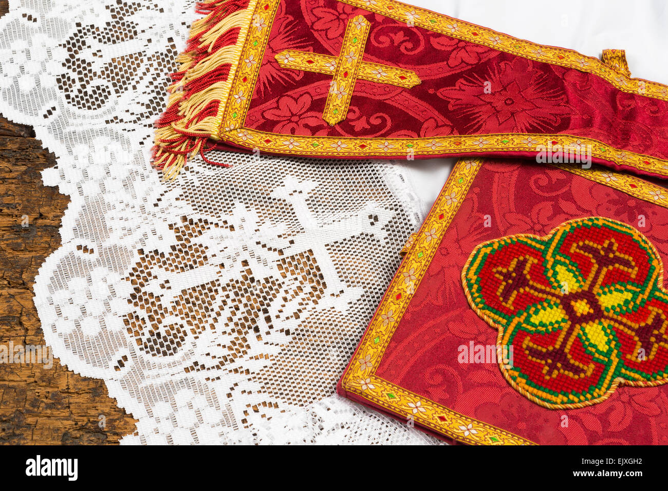 Antique red damask chalice veil and maniple on a white lace catholic priest surplice Stock Photo