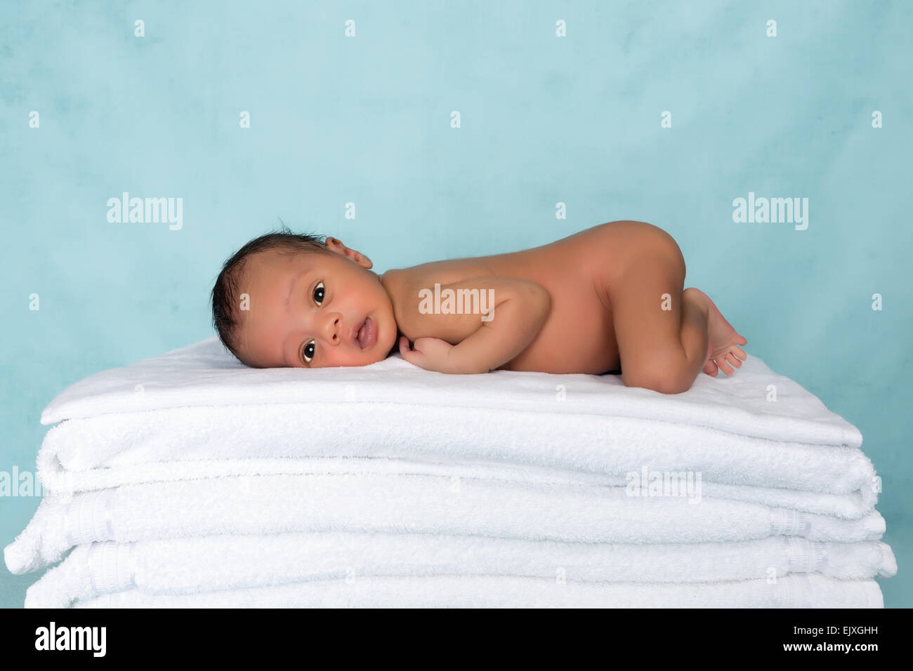 Adorable little biracial baby of 11 days old on a stack of towels Stock Photo